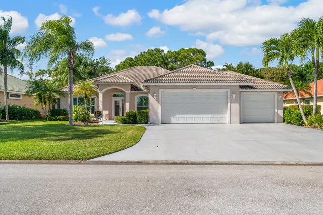 front view of a house with a yard and an trees
