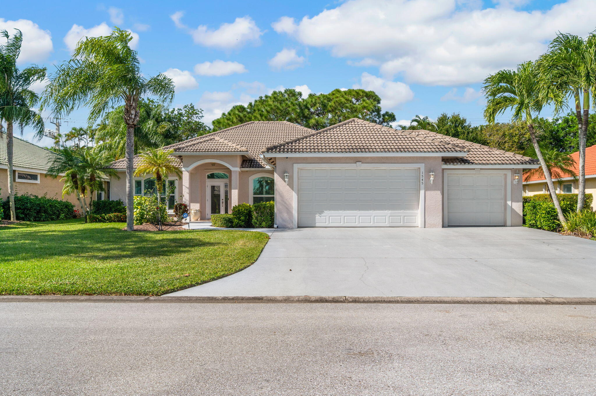 1545 Southwest Mockingbird Circle Port St. Lucie, FL 34986 - Photo 2 of 24 front view of a house with a yard and an trees