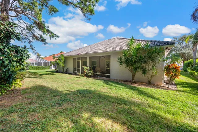 a view of a house with a yard and potted plants