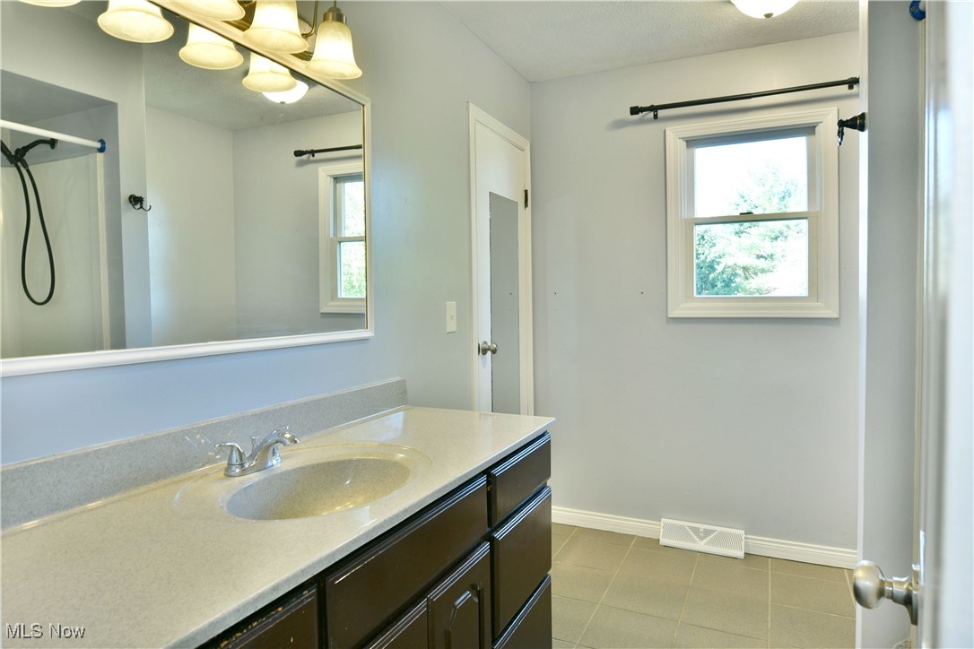 4461 Ridge Road Cortland, OH 44410 - Photo 21 of 47 Bathroom with tile patterned flooring, vanity, and a shower