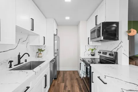 a kitchen with stainless steel appliances a stove sink and microwave