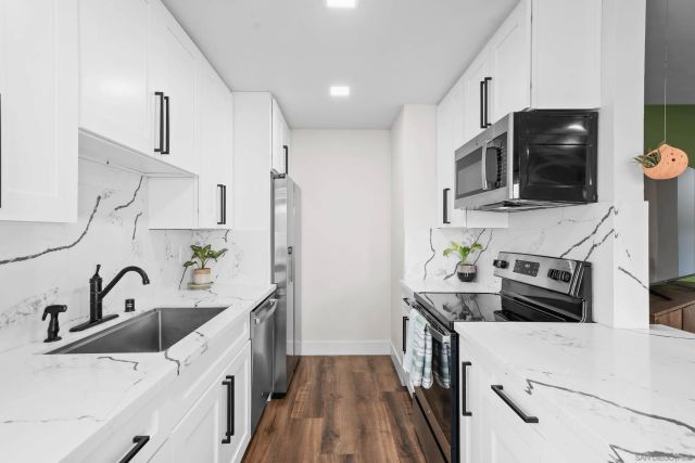 a kitchen with stainless steel appliances a stove sink and microwave