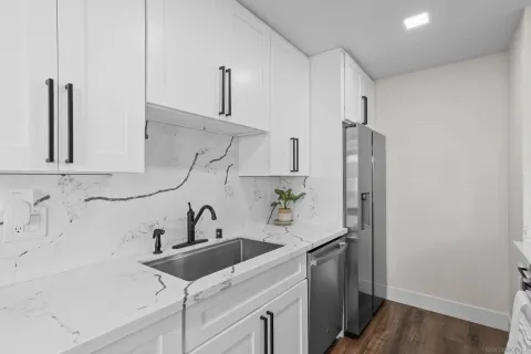 a kitchen with stainless steel appliances a sink and a refrigerator