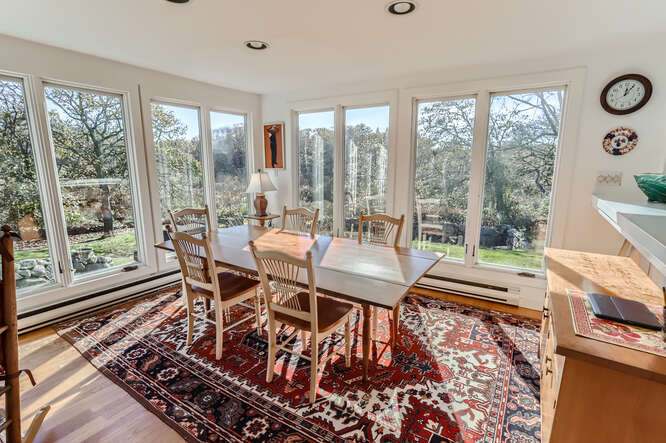 76 State Road Chilmark, MA 02535 - Photo 26 of 79 a dining room with furniture a rug and a floor to ceiling window