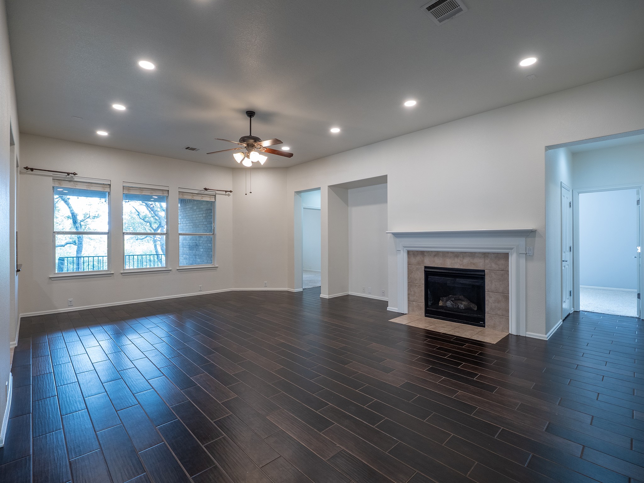 572 Big Meadow Road Austin, TX 78737 - Photo 2 of 32 A spacious living area features elegant dark tile flooring and a cozy fireplace, perfect for gatherings.