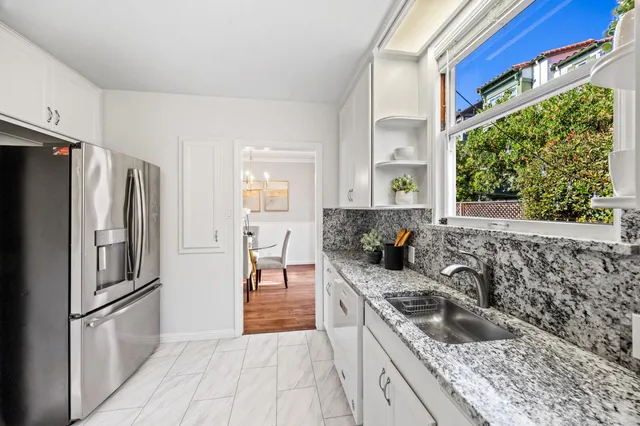 a kitchen with granite countertop a refrigerator and a sink