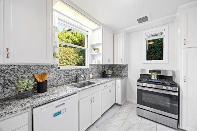 a kitchen with granite countertop a sink and a window
