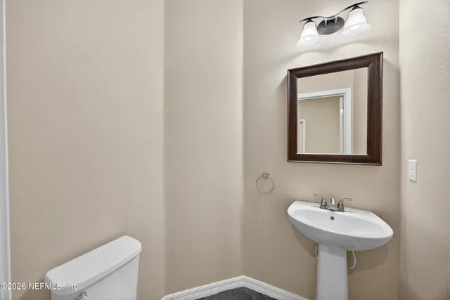 a bathroom with a toilet sink and mirror