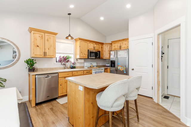 972 West 2840th Street South Logan, UT 84321 - Photo 7 of 46 Kitchen featuring wood-finish flooring, vaulted ceiling, and light wood cabinetry