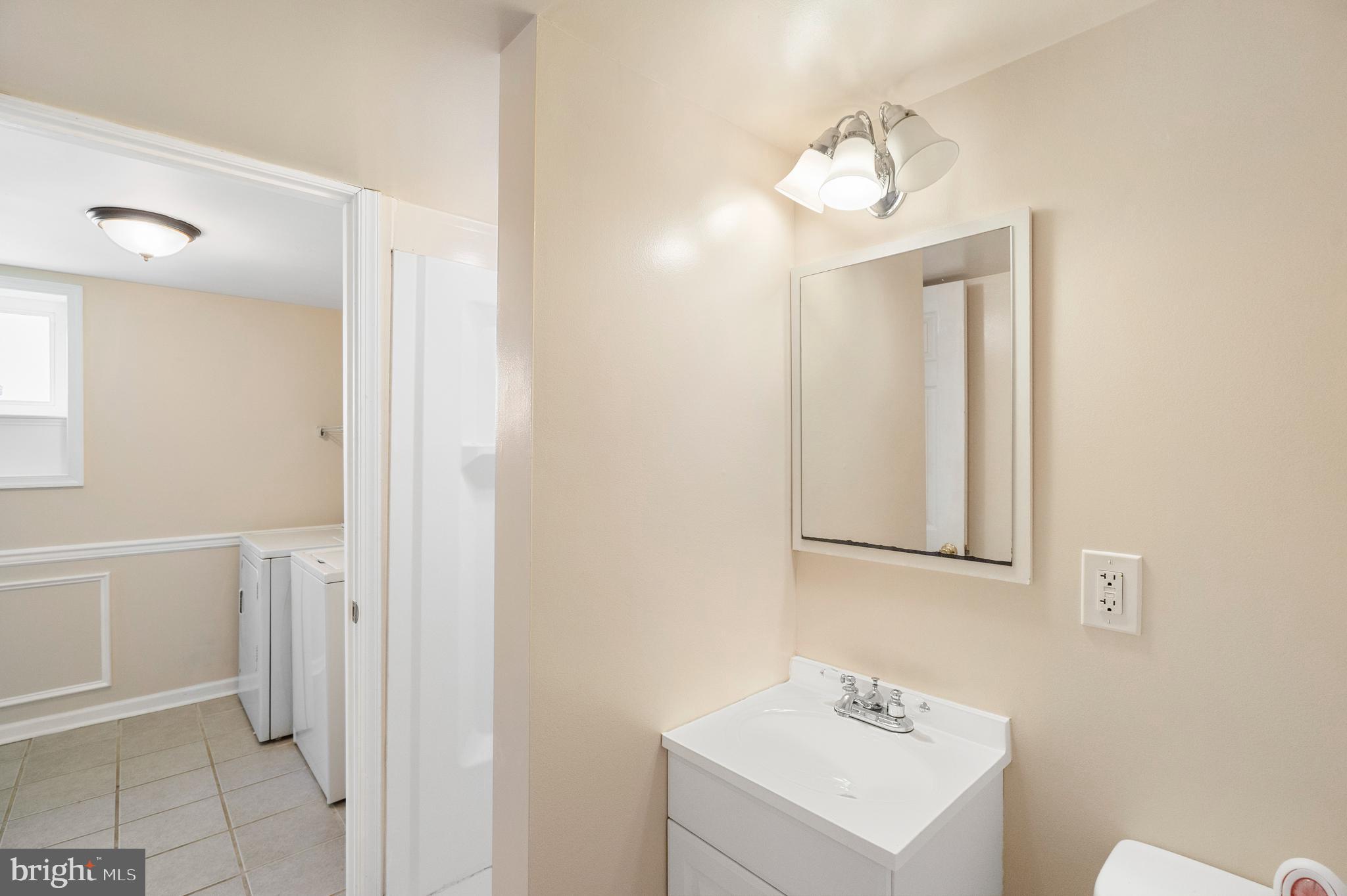 2114 Oakland Road Baltimore, MD 21220 - Photo 14 of 21 a bathroom with a sink a mirror and a toilet
