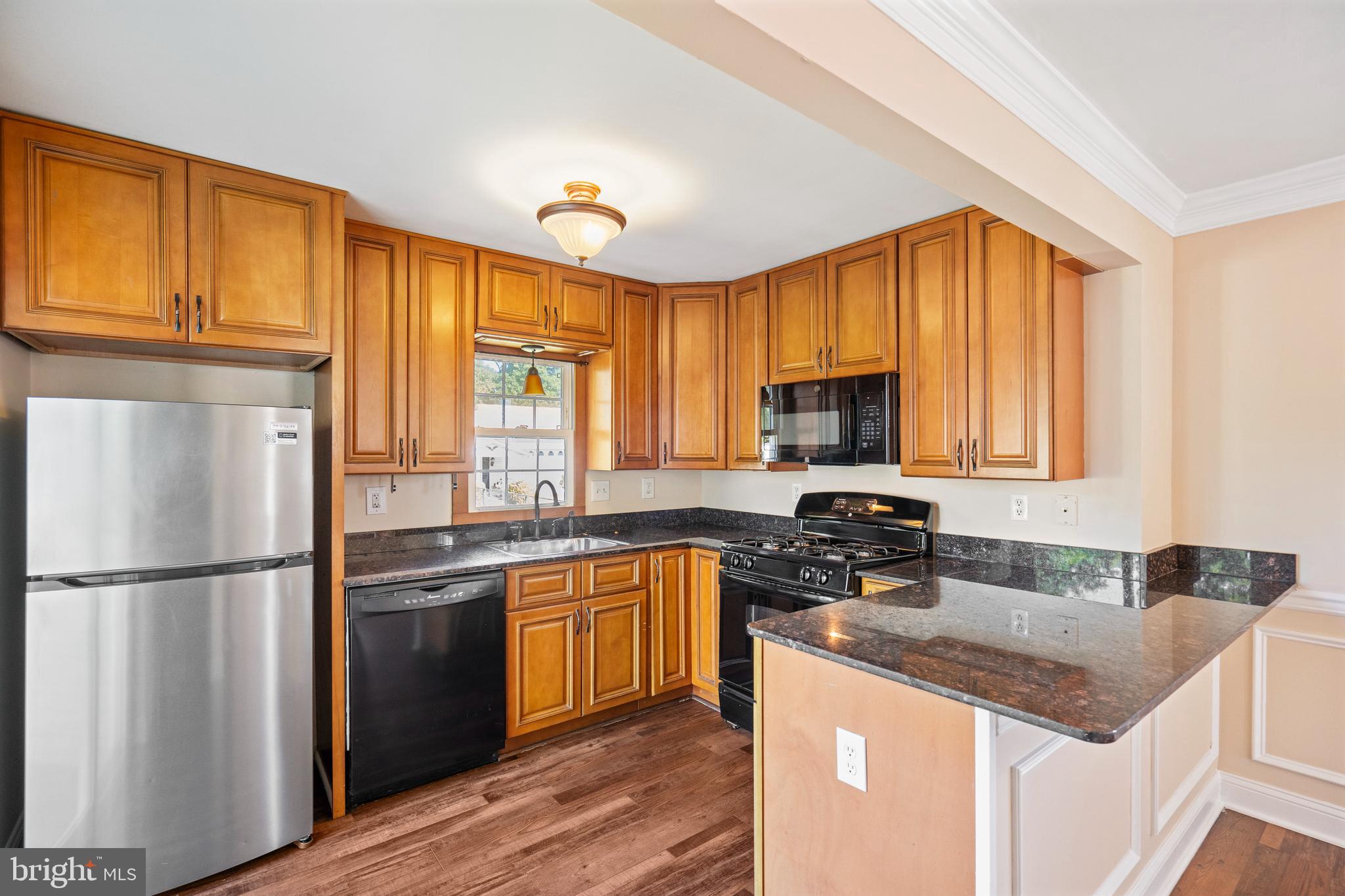 2114 Oakland Road Baltimore, MD 21220 - Photo 6 of 21 a kitchen with stainless steel appliances granite countertop a refrigerator a sink dishwasher a stove and white countertops with wooden floor