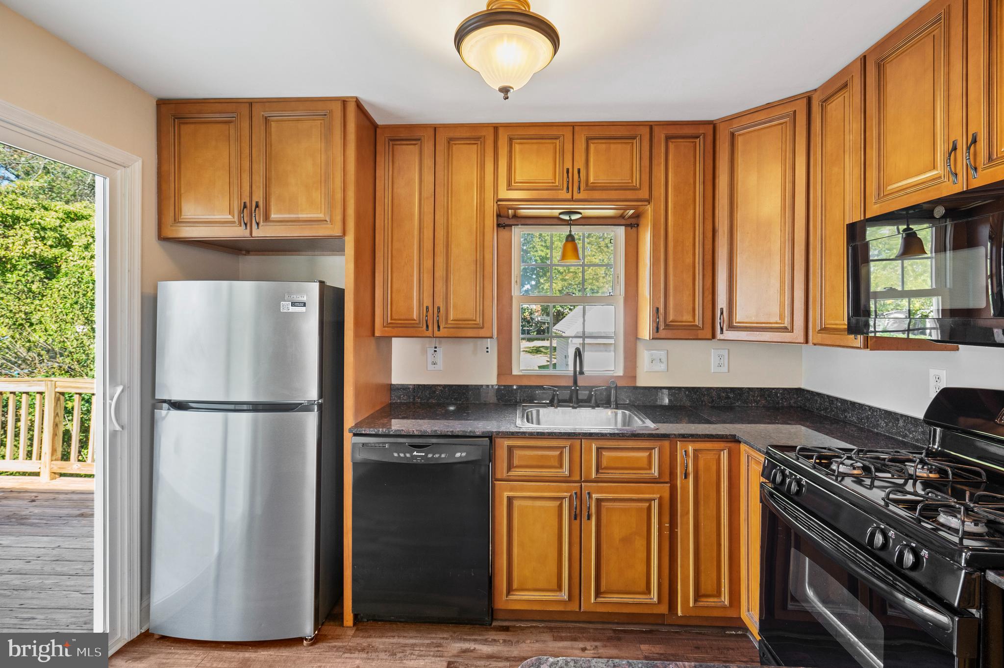 2114 Oakland Road Baltimore, MD 21220 - Photo 7 of 21 a kitchen with granite countertop a refrigerator a sink dishwasher stove and cabinets