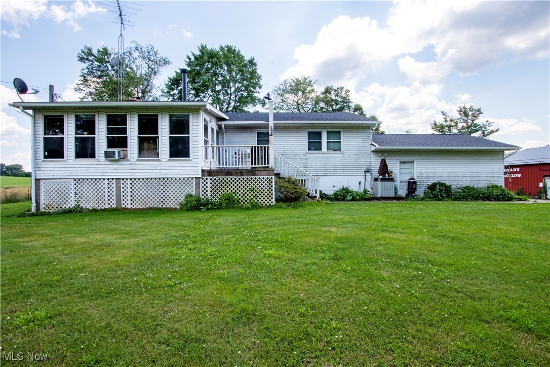 1292 Cinder Road Southeast Carrollton, OH 44615 - Photo 4 of 42 Rear view of house featuring a yard and cooling unit