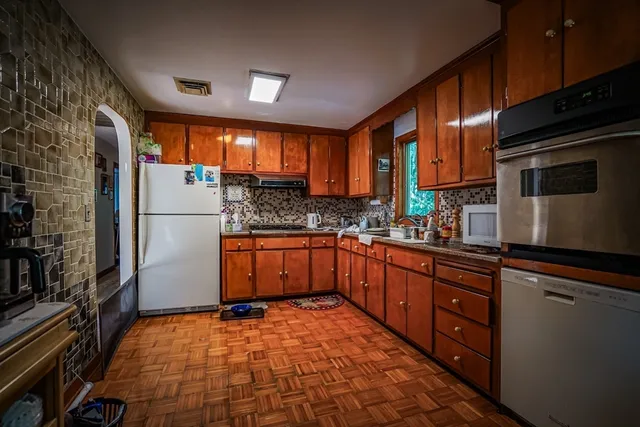 a kitchen with stainless steel appliances granite countertop a refrigerator a stove top oven a sink and dishwasher