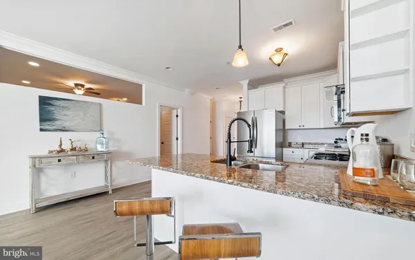 a kitchen with stainless steel appliances granite countertop a sink stove and cabinets