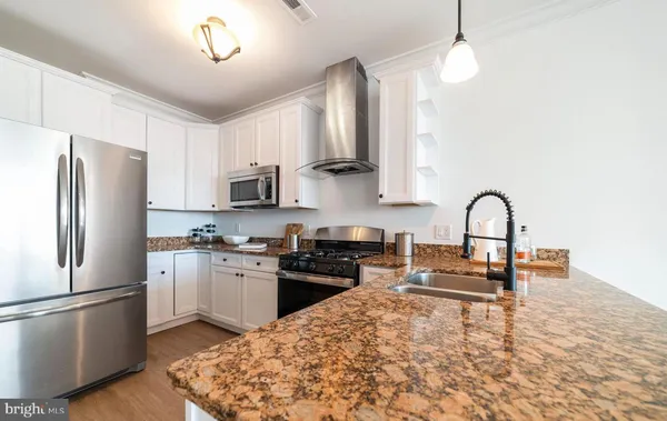 a kitchen with stainless steel appliances granite countertop a refrigerator a stove a sink and a stove