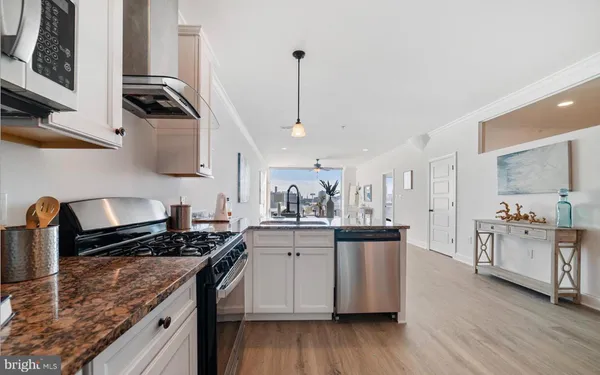 a kitchen with stainless steel appliances granite countertop a stove a sink and a refrigerator