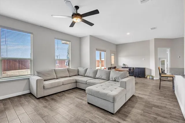 a living room with furniture and a ceiling fan