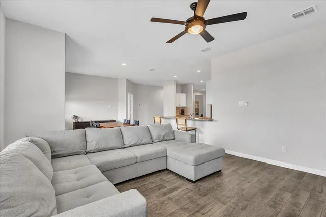 a living room with furniture ceiling fan and a window