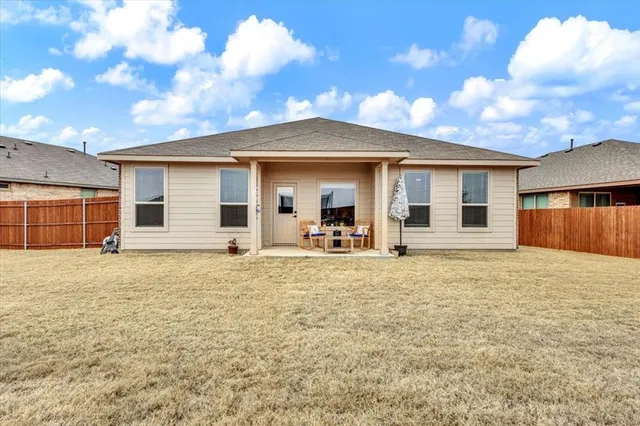 a backyard of a house with table and chairs