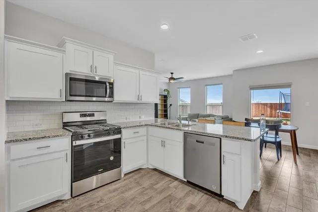 a kitchen with white cabinets and sink