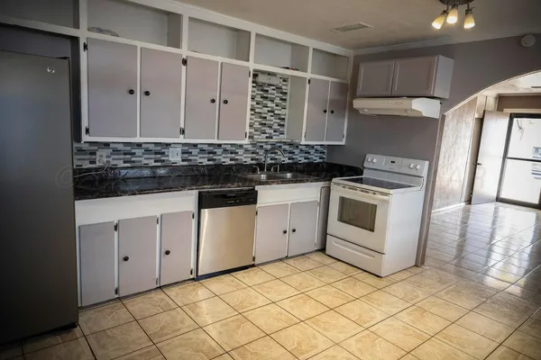 a kitchen with granite countertop white cabinets and white appliances
