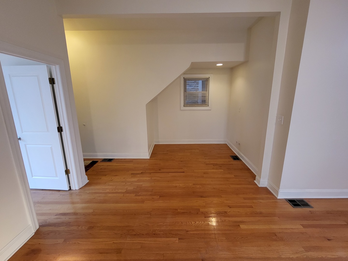 Undisclosed Address Chicago, IL 60622 - Photo 3 of 15 a view of an empty room with wooden floor and a window