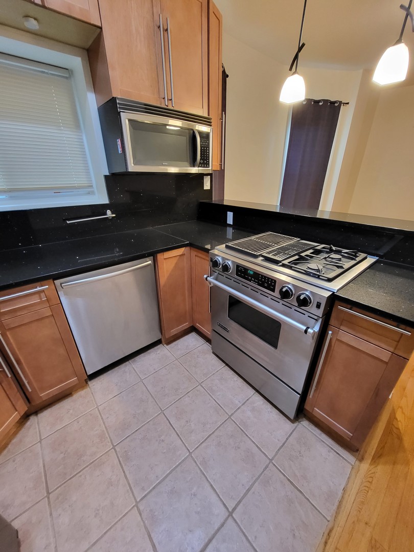 Undisclosed Address Chicago, IL 60622 - Photo 6 of 15 a kitchen with wooden cabinets and a stove top oven