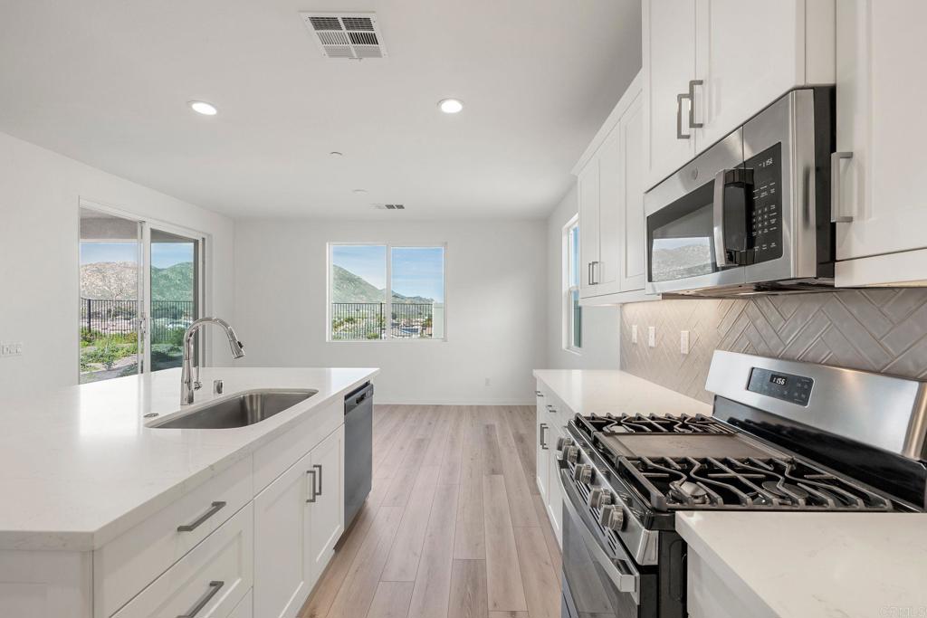 5384 Viewstone Court Hemet, CA 92545 - Photo 17 of 47 a kitchen with stainless steel appliances a sink a stove and cabinets