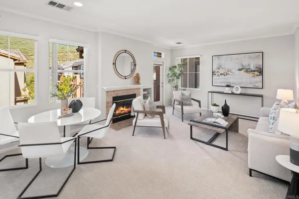 a living room with furniture a clock on wall and a window
