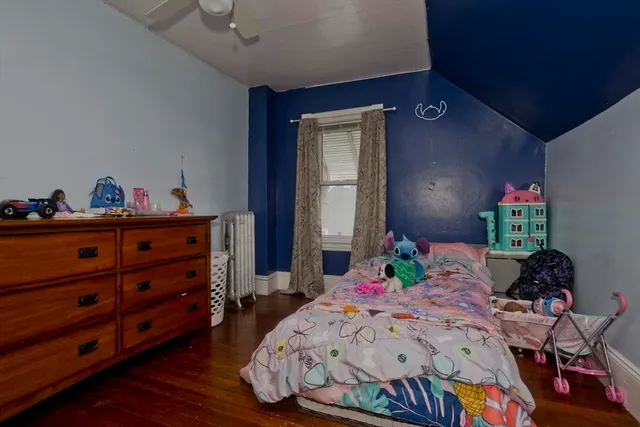 a bedroom with bed and a wooden floor