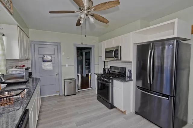 a kitchen with stainless steel appliances granite countertop a stove a sink and a refrigerator