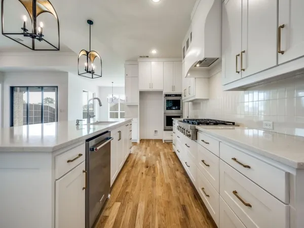 a large kitchen with stainless steel appliances granite countertop a lot of counter space and a sink