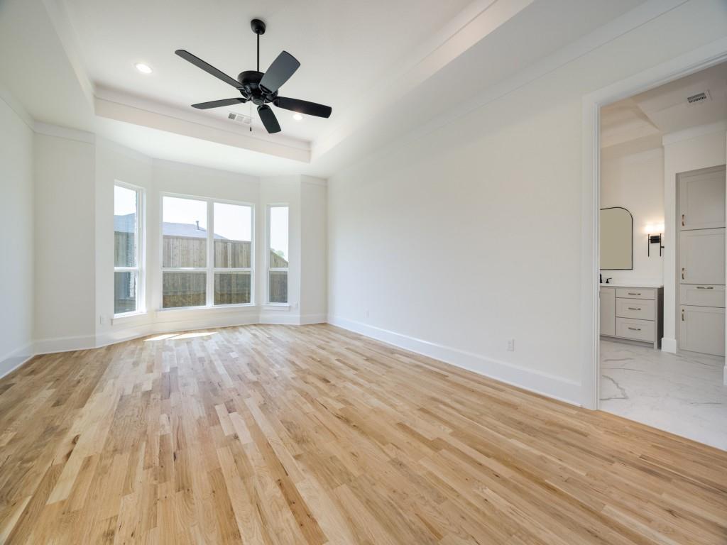 301 Fairmount Court Denton, TX 76210 - Photo 13 of 28 a view of empty room with wooden floor and ceiling fan