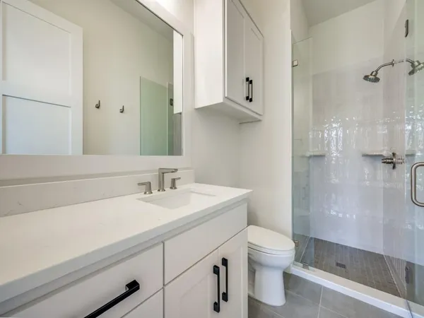 a bathroom with a tub sink vanity and mirror