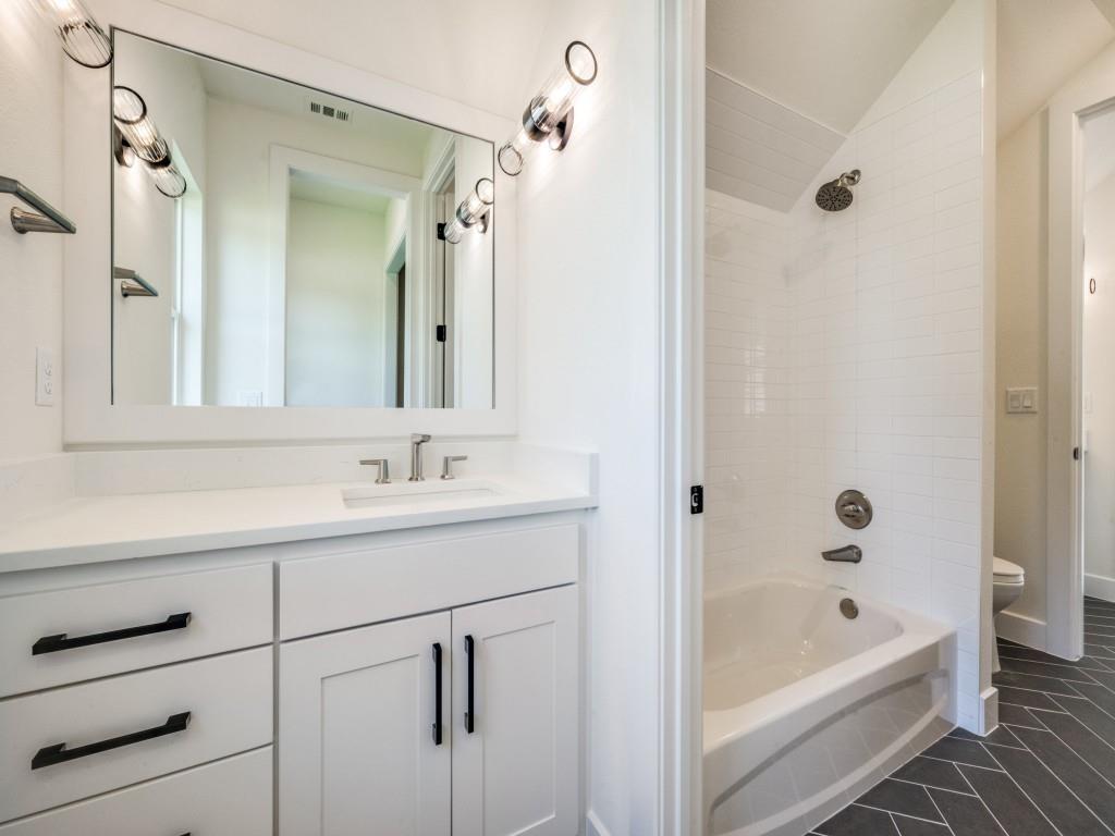 301 Fairmount Court Denton, TX 76210 - Photo 19 of 28 a bathroom with a tub sink vanity and mirror