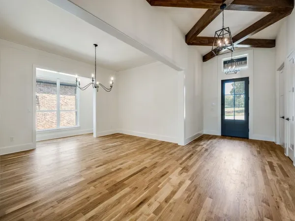 a view of empty room with wooden floor ceiling fan and window