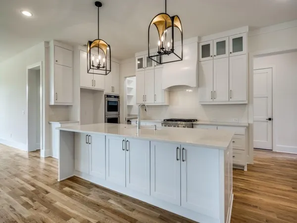a kitchen with stainless steel appliances granite countertop a sink a stove and cabinets