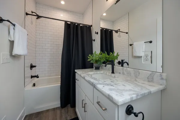 a bathroom with a granite countertop sink a shower and a mirror