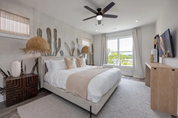 a bedroom with a large bed a flat tv screen and a dresser