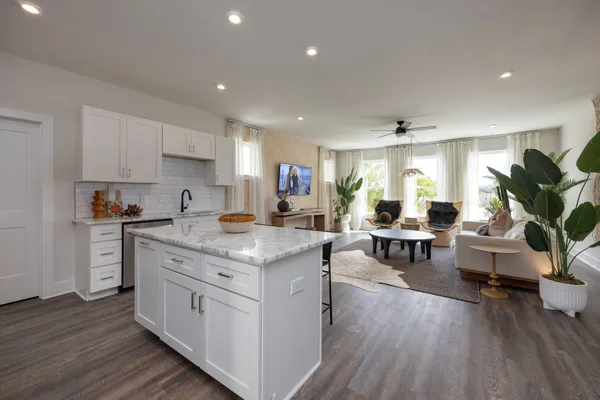 a kitchen with stainless steel appliances granite countertop wooden floors and view living room