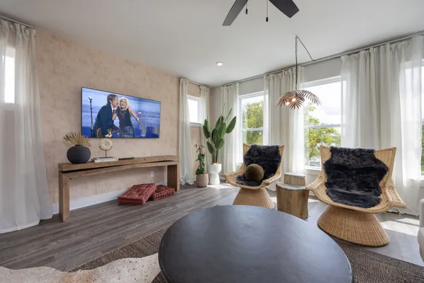 a living room with furniture a window and a flat screen tv