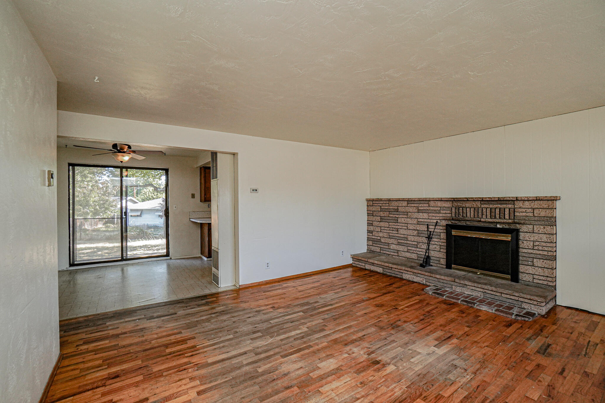 2540 Merriman Road Medford, OR 97501 - Photo 3 of 15 Living room with woodburning fireplace and original hardwood floors.