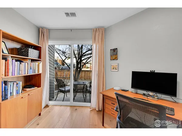 a view of a workspace with furniture and a window