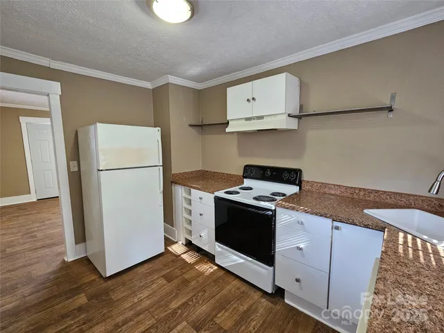 a kitchen with granite countertop a refrigerator and a stove