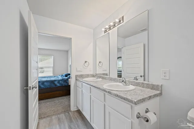 a en suite bathroom with a granite countertop sink and a mirror