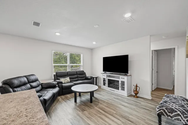 a living room with furniture a flat screen tv and a window