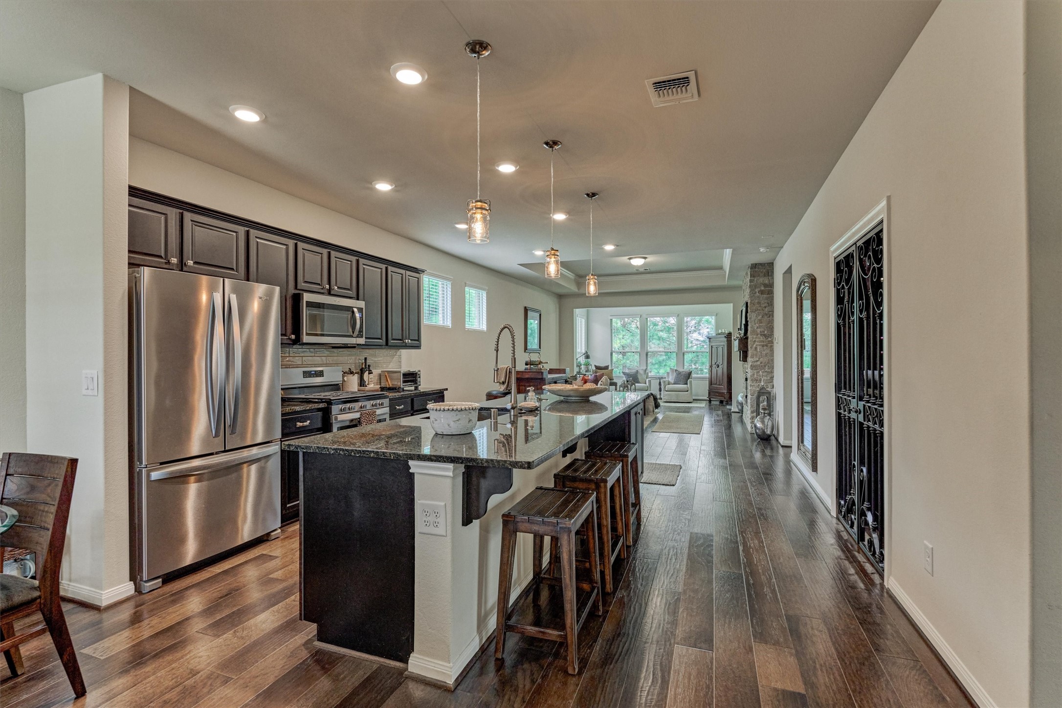 128 Caspian Way Spring Spring, TX 77382 - Photo 8 of 48 a kitchen with stainless steel appliances granite countertop a refrigerator a stove top oven a sink dishwasher and chairs with wooden floor