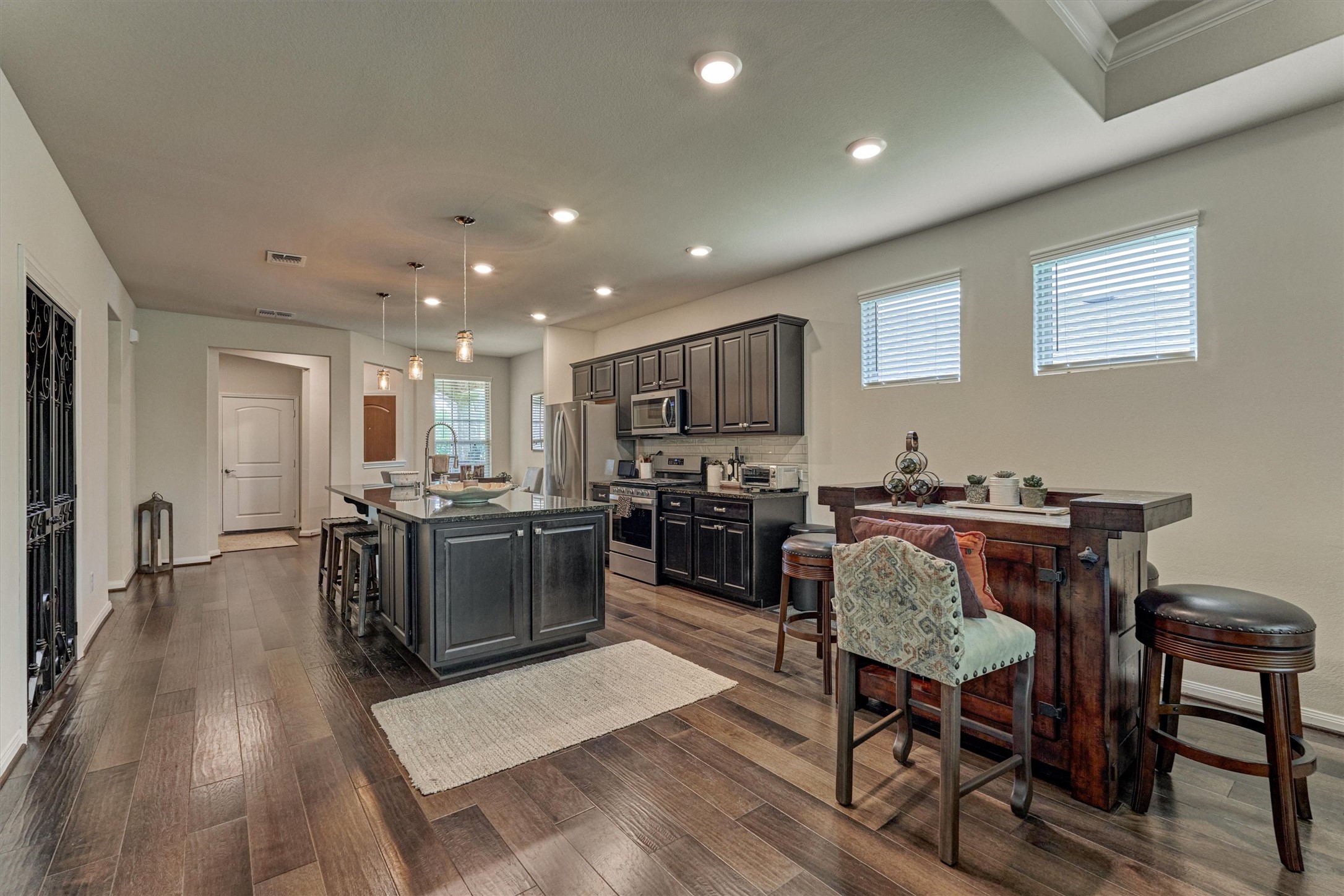 128 Caspian Way Spring Spring, TX 77382 - Photo 10 of 48 a kitchen with a table chairs microwave and cabinets