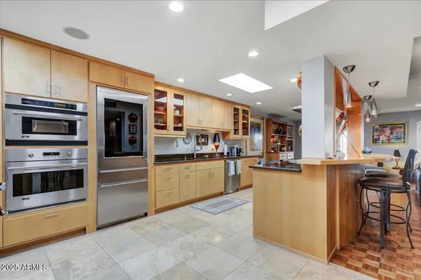 a kitchen with stainless steel appliances kitchen island granite countertop a stove and cabinets